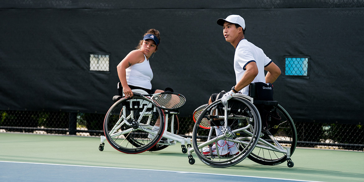 Wheelchair players on a court in doubles match.