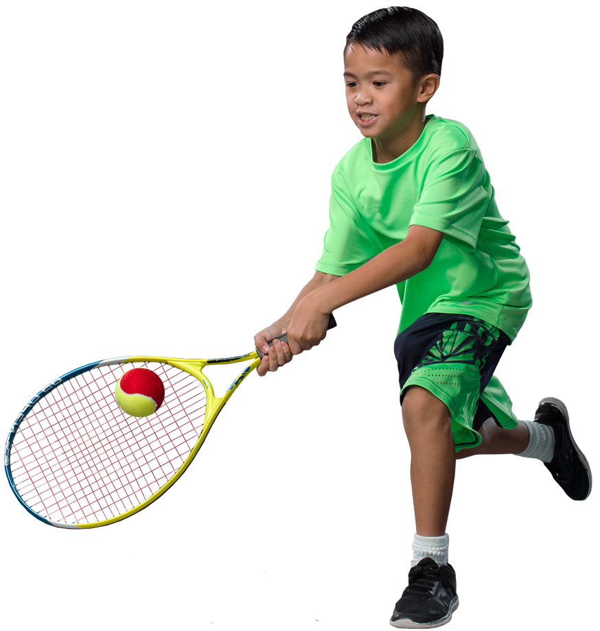 Young boy hitting a red tennis ball with a backhand technique.