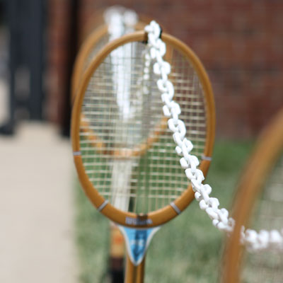 Decorative wooden racquets hanging on a chain.