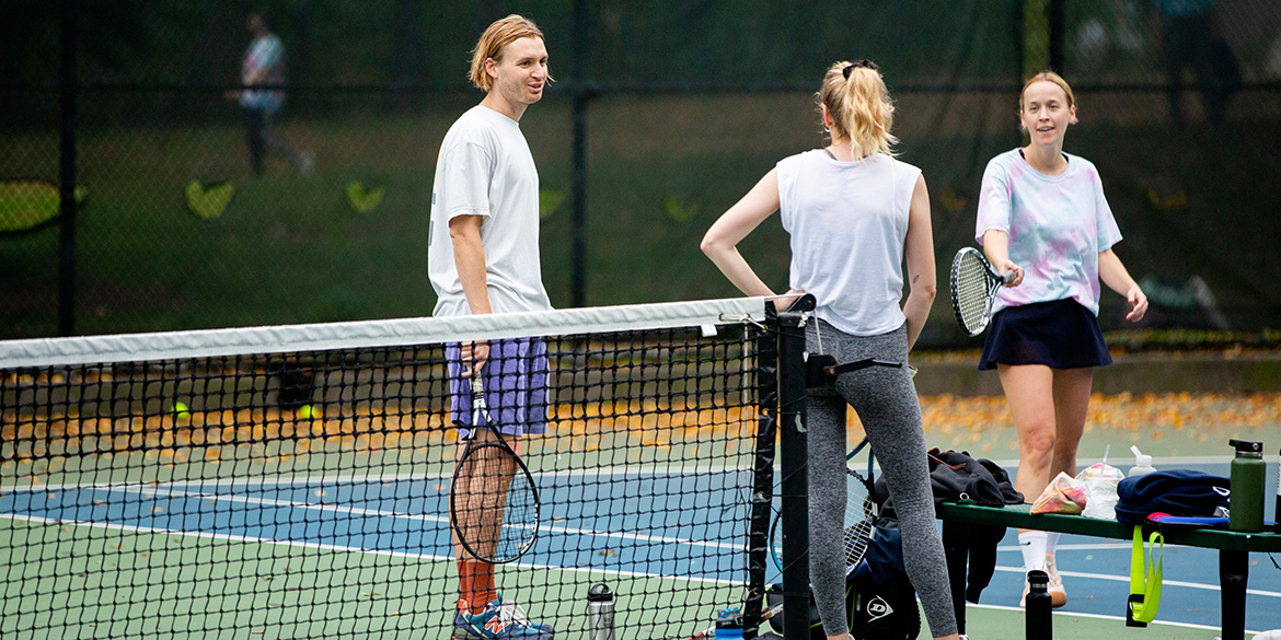 Players standing on tennis court talking.