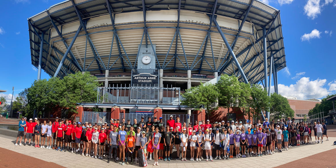 2022 Junior Team Tennis Sectional Championship participants take a photo in front of Arthur Ashe Stadium.