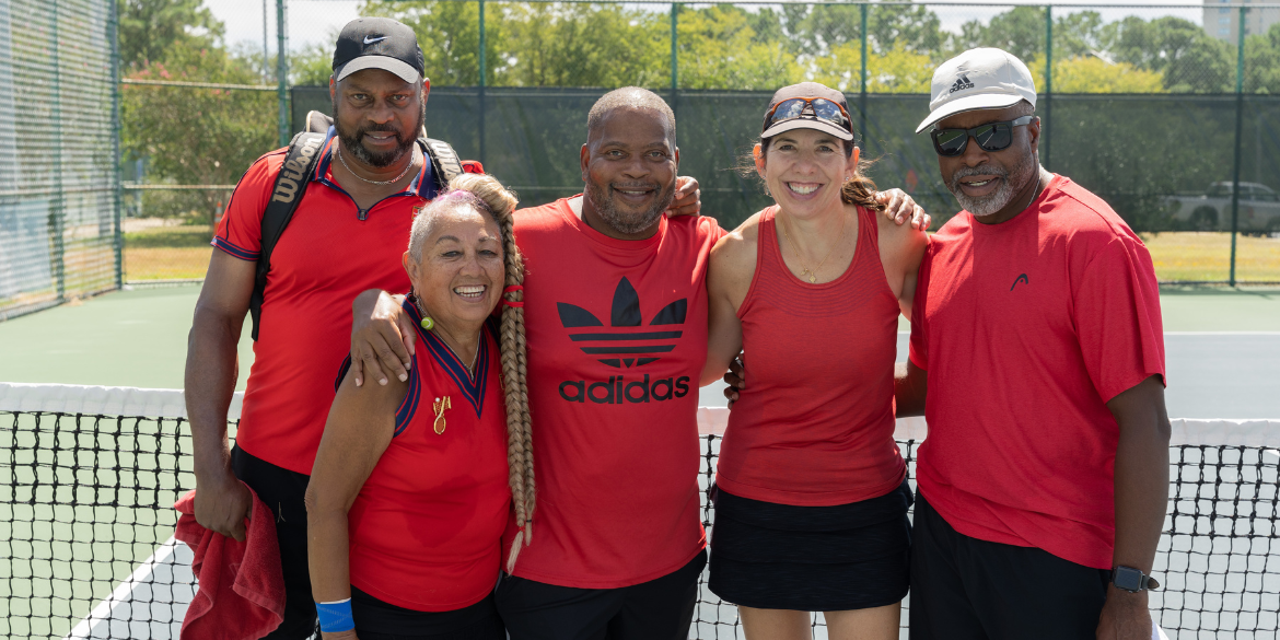 3 men and 2 women smiling at the camera on the tennis court