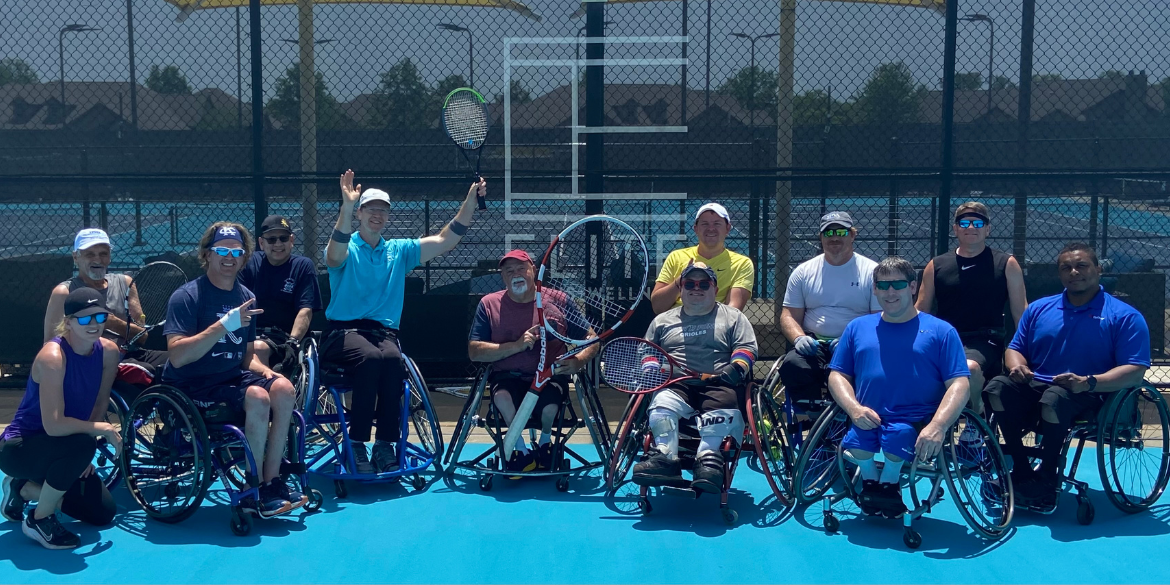A photo of a wheelchair tennis team on a tennis court.