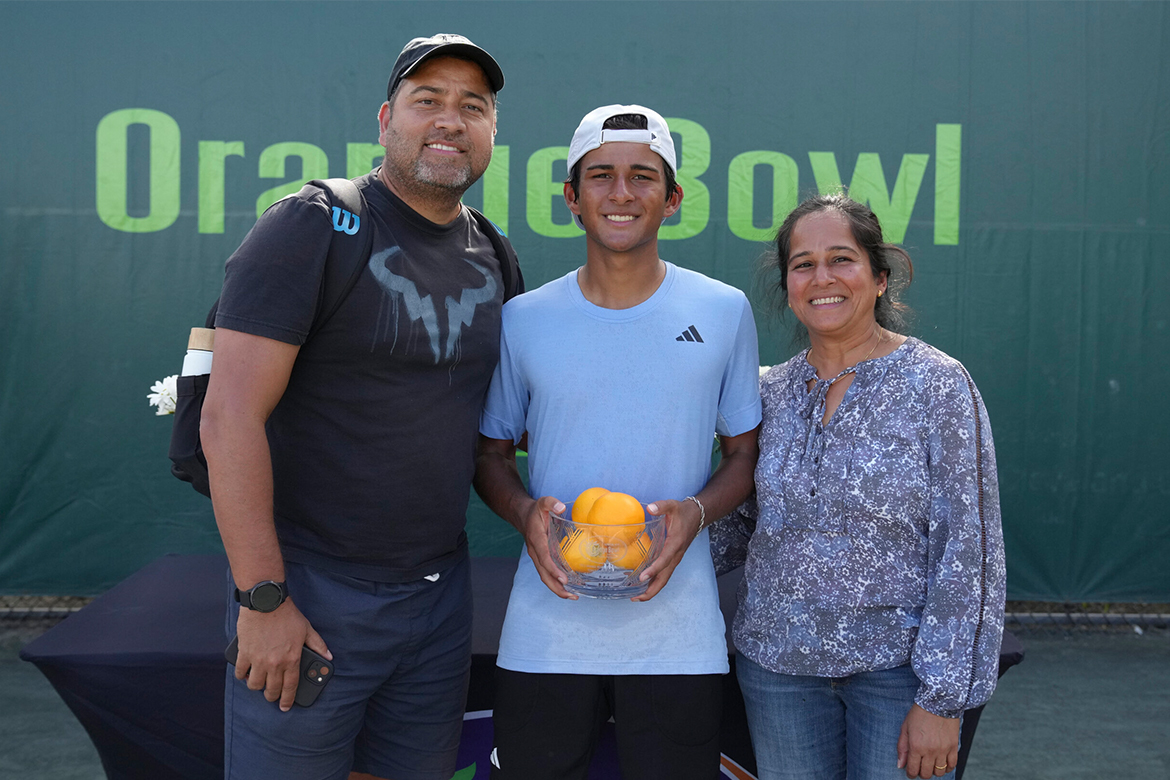 A junior player poses with his parents.
