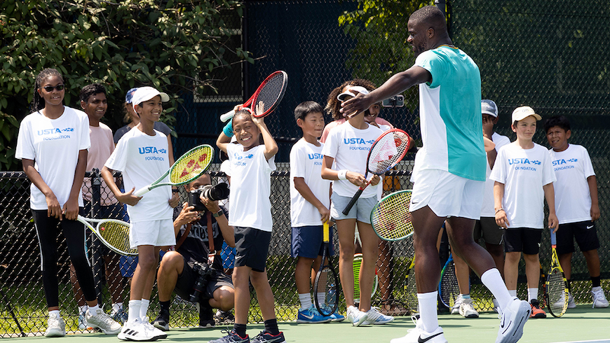Frances Tiafoe smiling with kids.